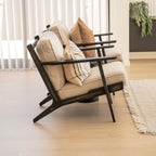 Modern black frame chair with beige cushions in a bright room.