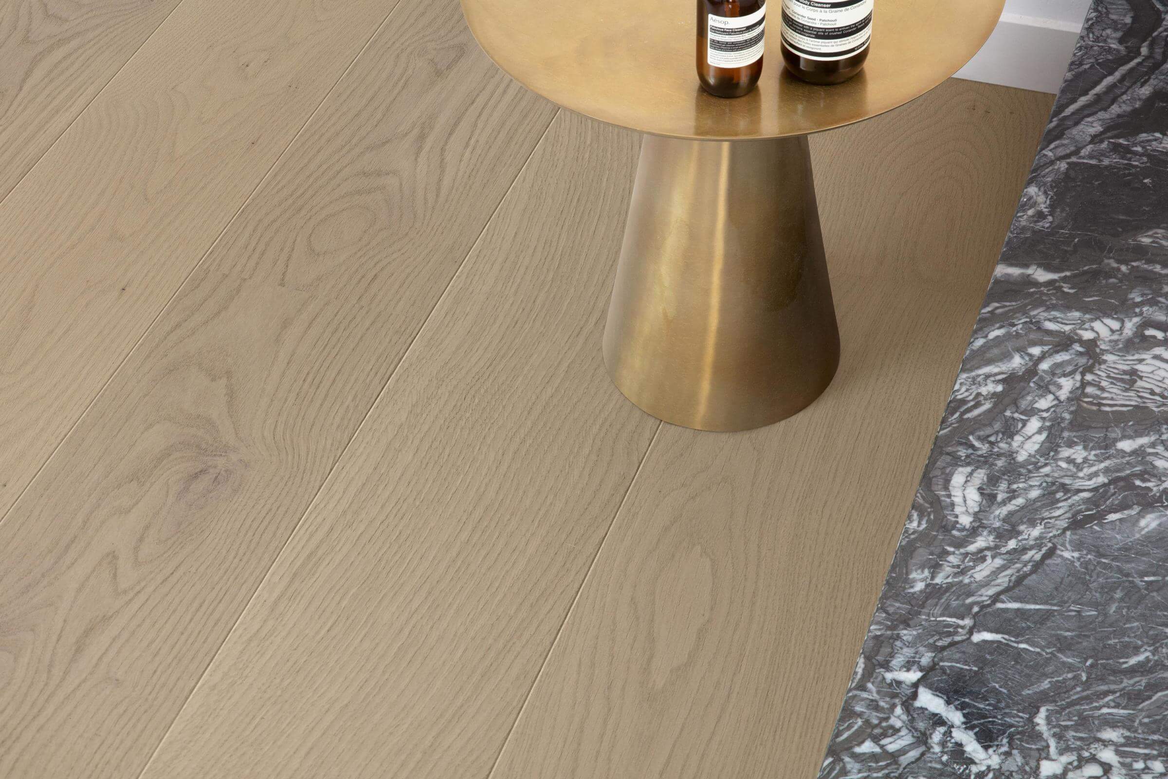 Wooden floor with a gold side table and marble surface