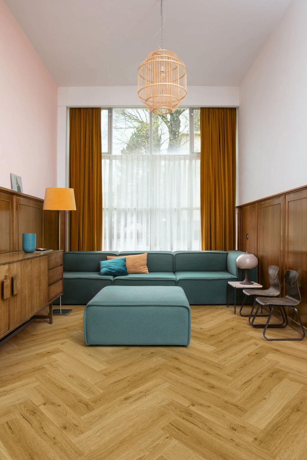 Modern living room with teal sectional sofa, wooden floor, and large window.