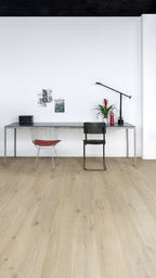 Modern office setup with a desk, chairs, and decor on a light wood floor.