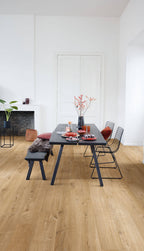 Modern dining area with a black table and chairs on a wooden floor.