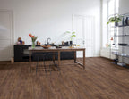Modern kitchen with wooden flooring, table, and chairs.