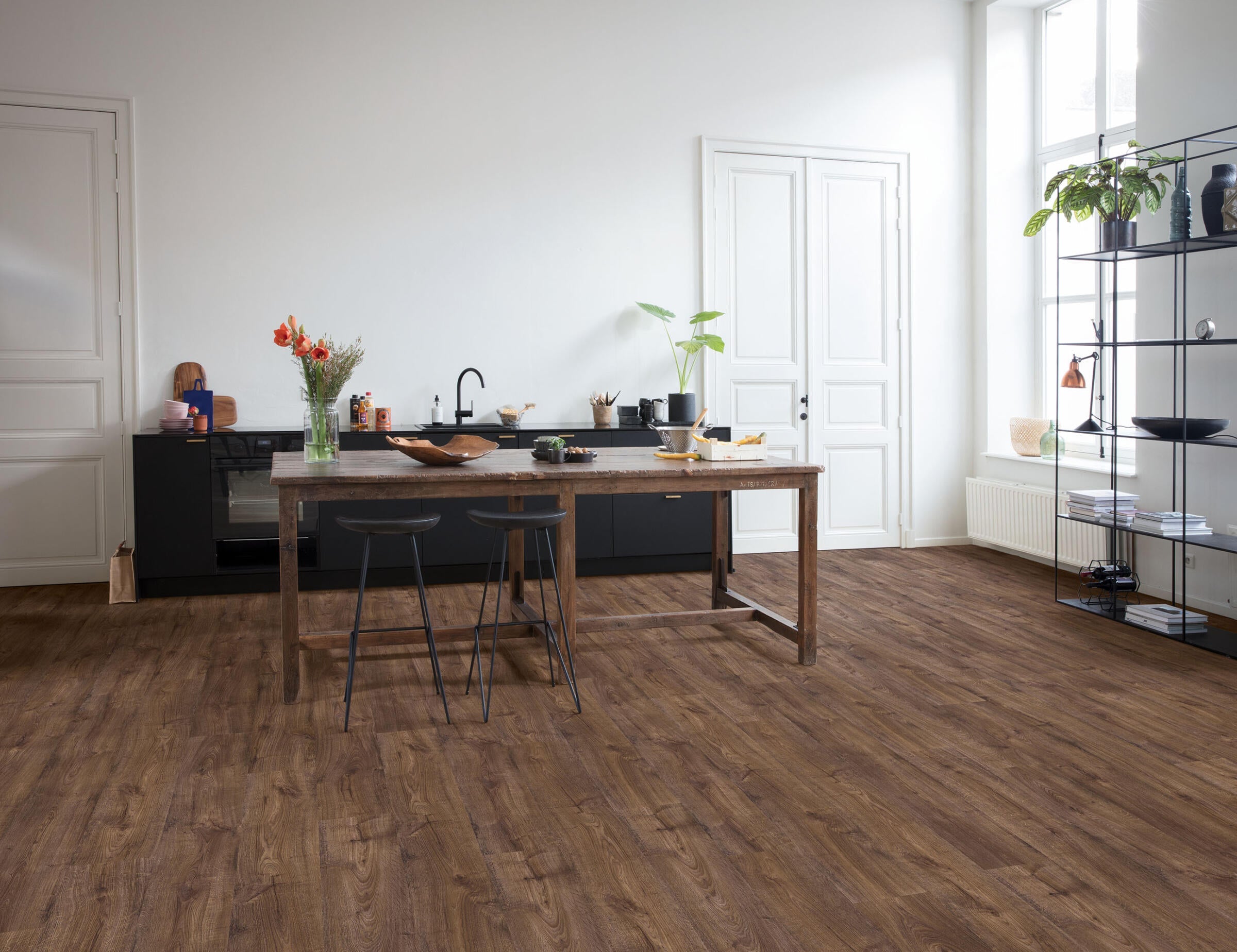 Modern kitchen with wooden dining table and chairs on a wooden floor.