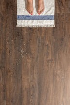 Wooden floor with a rug and feet on it