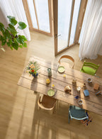 Dining area with a wooden table, chairs, and decorative items in a bright room.