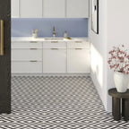 Modern kitchen with white cabinets, geometric black and white floor tiles, and decorative elements.