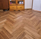 Wooden floor with herringbone pattern in a room with wooden furniture.