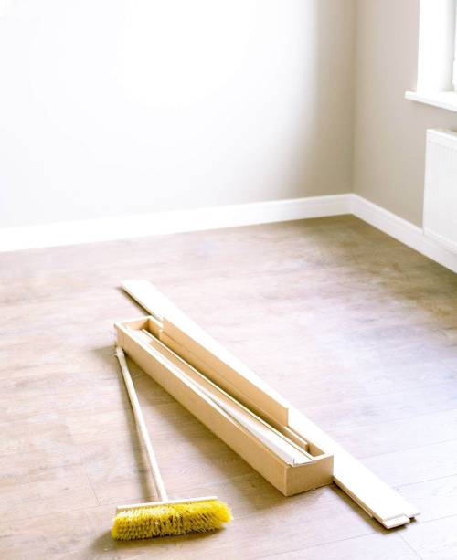 A broom laying on a timber floor