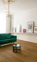 Modern living room with a green sofa, round coffee table, and wall art.