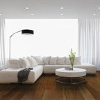 Modern living room with a white sectional sofa, round coffee table, and floor lamp.