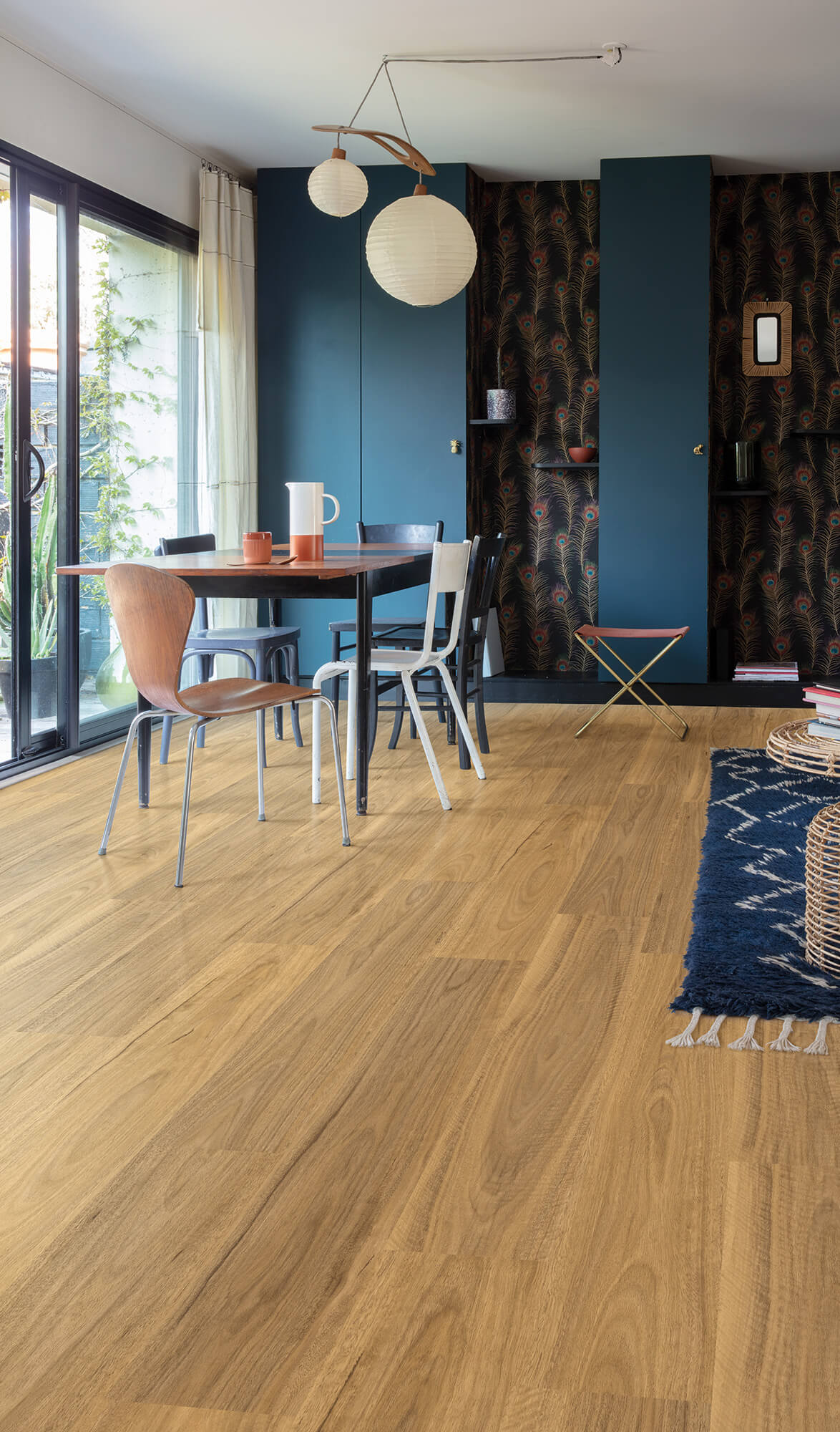 Modern interior with wooden flooring, dining table, and blue walls.