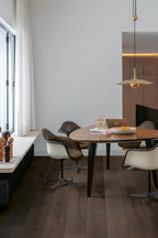 Modern dining area with a wooden table and chairs in a well-lit room.