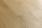 Light oak wood flooring planks with visible natural grain patterns and subtle seams.