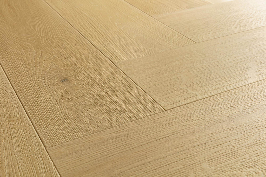 Light oak wood flooring planks arranged in a herringbone pattern, showing natural wood grain and a subtle knot.