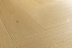 Light oak wood flooring planks arranged in a herringbone pattern, showing natural wood grain and a subtle knot.