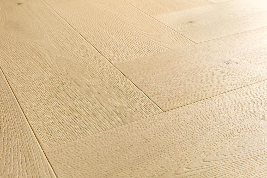 Light natural oak wood flooring planks arranged in a herringbone pattern, showing detailed wood grain and subtle knots.