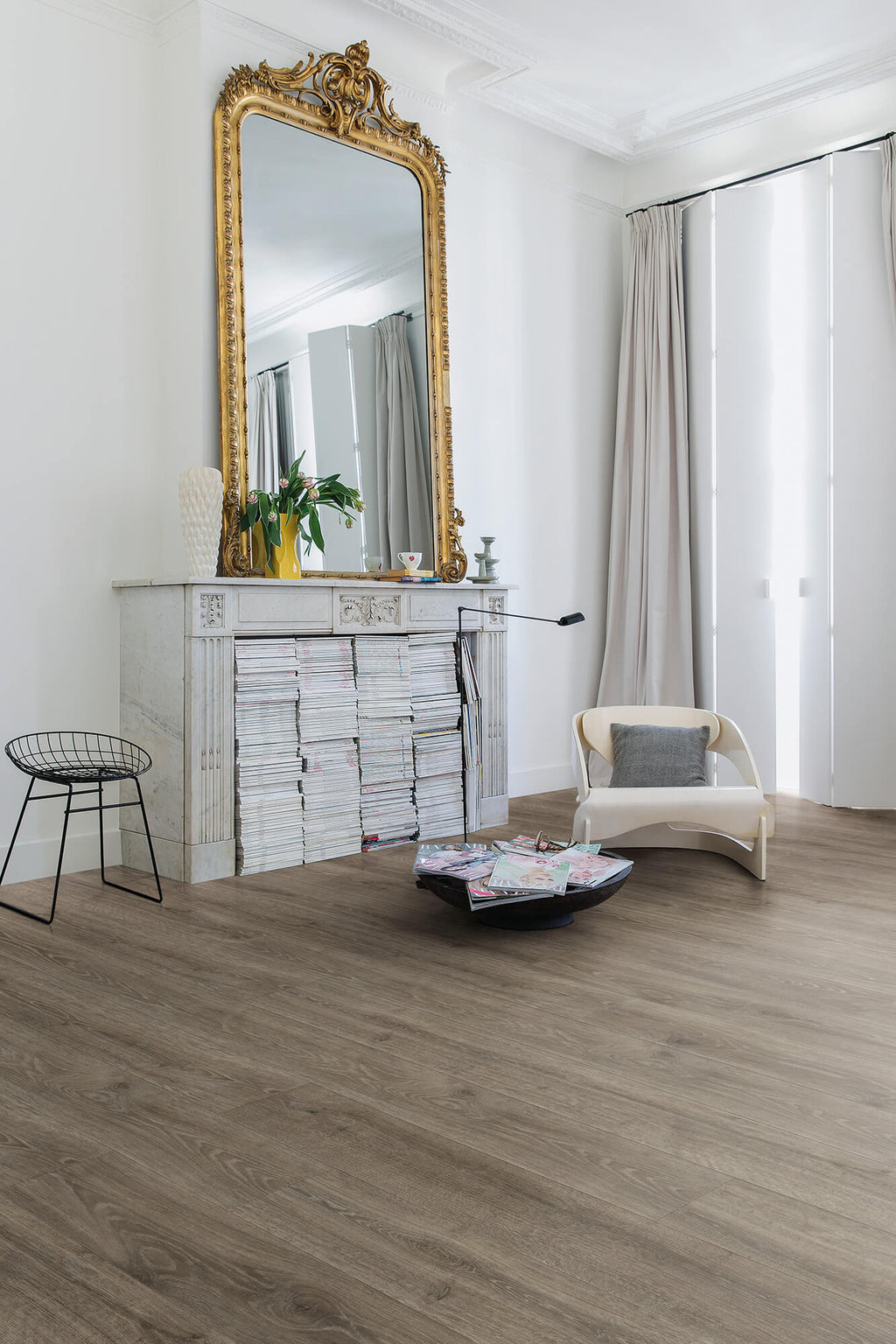 Living room with a large ornate mirror, white sofa, and wooden floor.