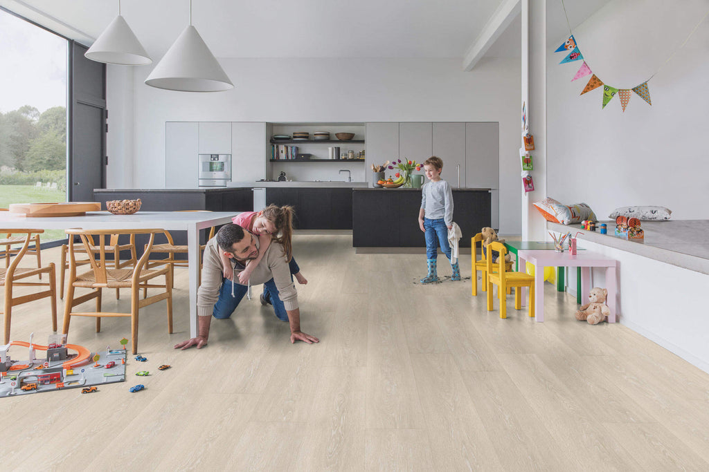 Family playing on a wooden floor in a modern kitchen