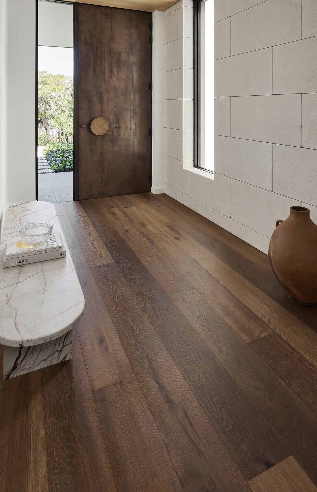 Modern interior with wooden flooring, a large window, and a decorative vase.