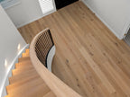 Wooden staircase with a modern design in a well-lit room.