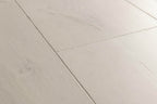 Close-up of a light gray wooden floor with a chevron pattern