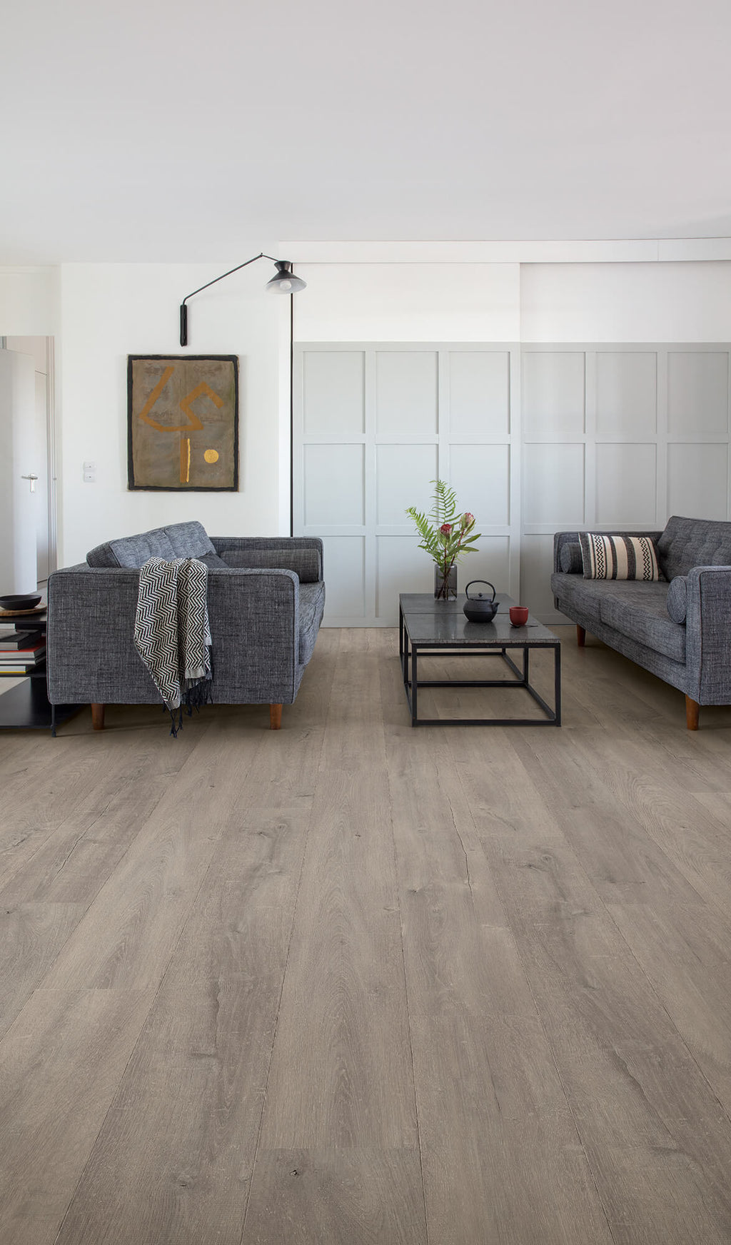 Modern living room with gray sofas, a coffee table, and decorative elements.