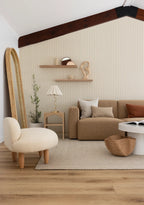 Modern living room with beige sofa, armchair, and decorative items.