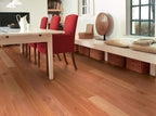 Dining room with wooden floor, red chairs, and a window.
