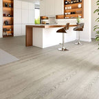 Modern kitchen with wooden flooring and bar stools.