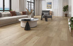 Modern living room with wooden flooring, furniture, and large windows.