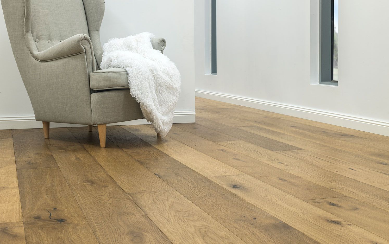 Wooden flooring in a room with a chair and white walls