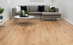 Living room with a gray sectional sofa, wooden coffee table, and light wood flooring.