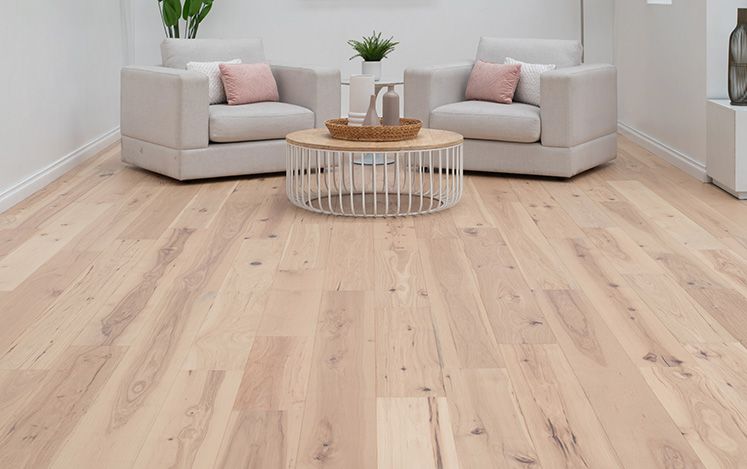Living room with light wood flooring, gray sofa, and decorative items.