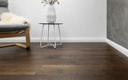 Wooden flooring in a room with a chair, table, and vase.