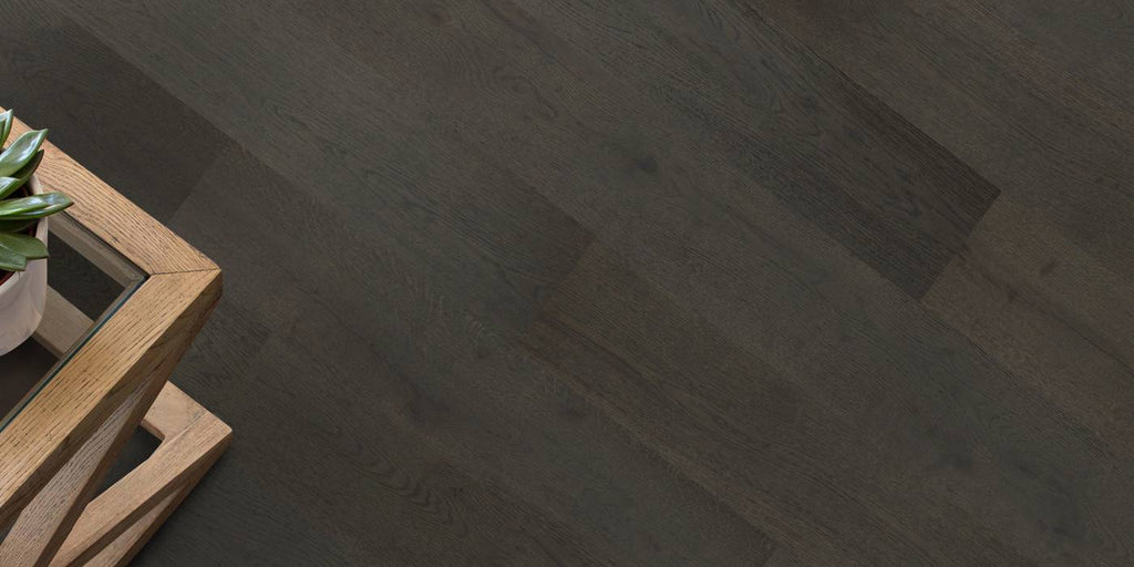 Dark wooden floor with a wooden side table and plant
