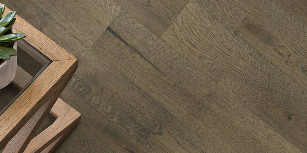Wooden floor with a herringbone pattern and a wooden table corner.