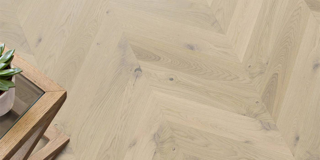 Wooden floor with a herringbone pattern and a wooden side table.