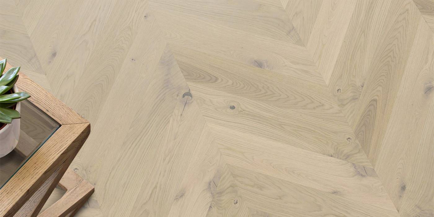 Wooden floor with a herringbone pattern and a wooden side table.