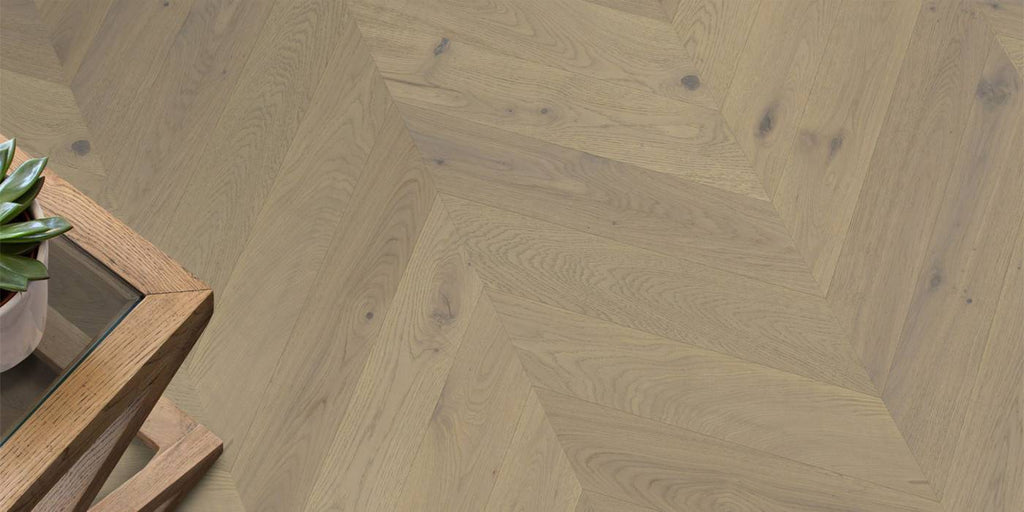 Wooden floor with a herringbone pattern and a wooden side table.