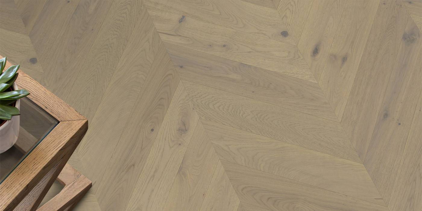 Wooden floor with a herringbone pattern and a wooden side table.