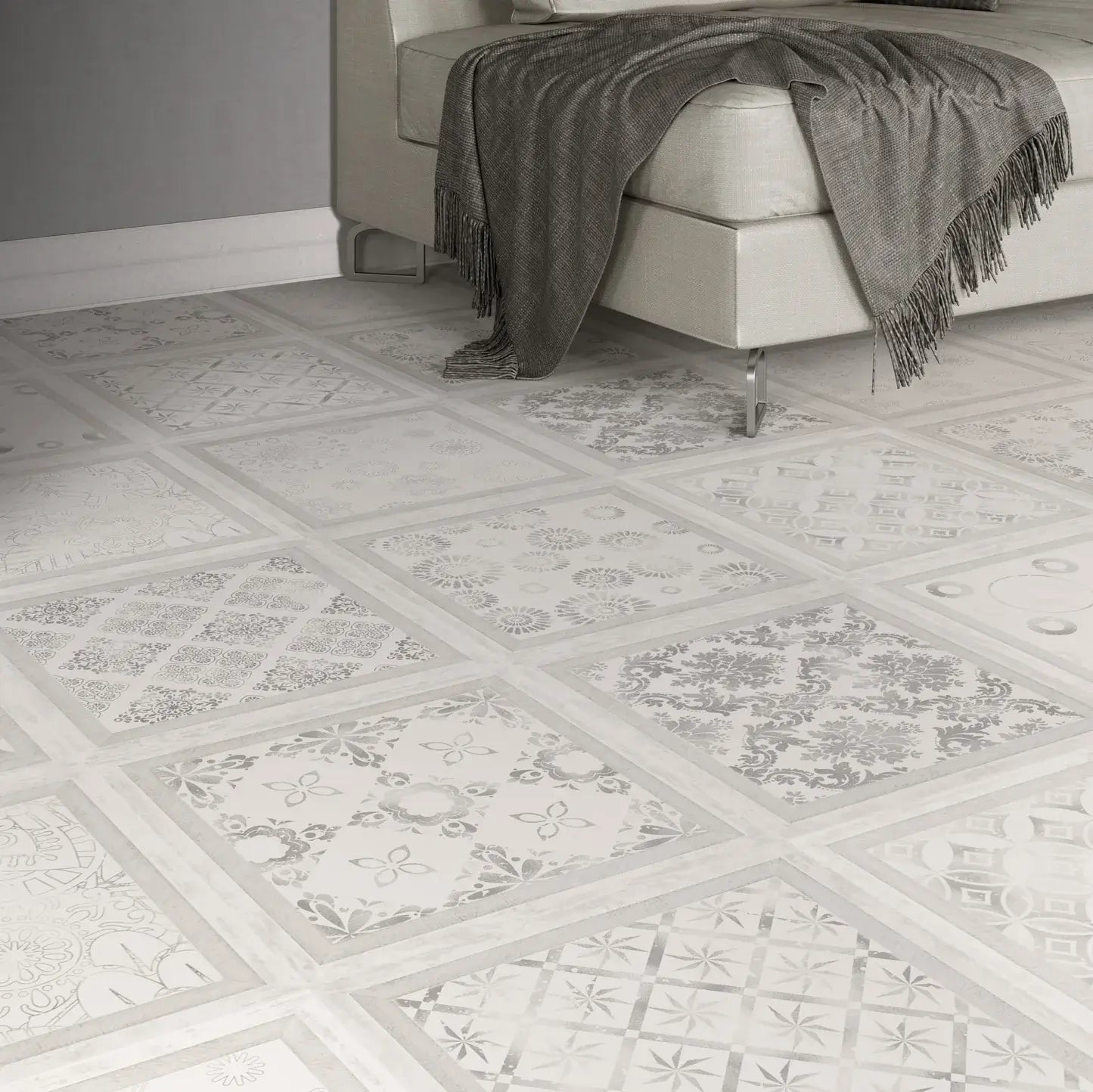 Decorative square floor tiles with a white and gray mosaic pattern, shown in a modern room setting with a light-colored sofa and a gray throw blanket.